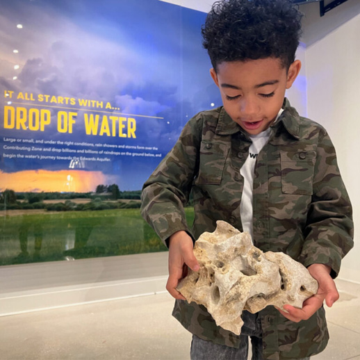 Visitor-with-limestone-rock-Edwards-Aquifer-Authority-EAAEOC